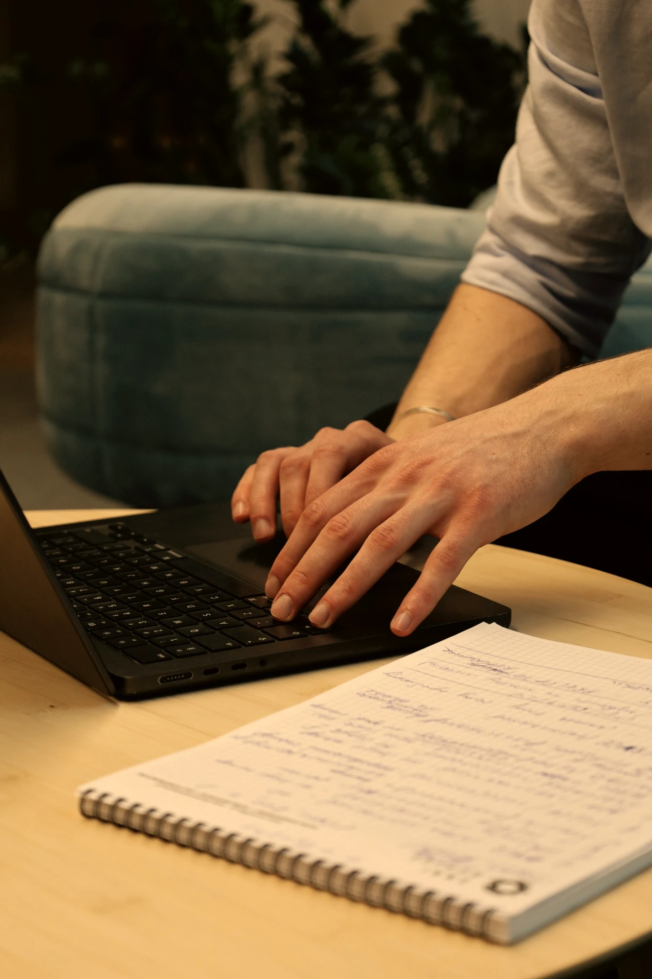 A consultant typing on a laptop beside handwritten notes