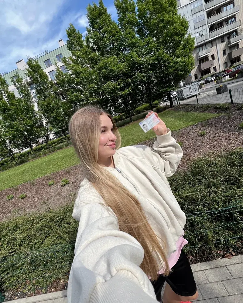 A client holding a new Polish residence card outside the immigration office in Warsaw